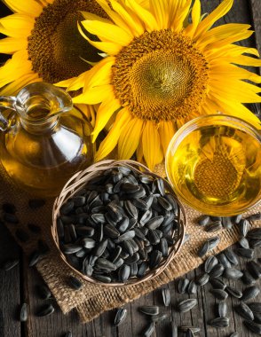 Ayçiçek yağı ve küçük torba geleneksel rustik ahşap arka plan ayçiçeği çekirdeği. Organik ve eko gıda kavramı. Sağlıklı gıda ve yağlar.