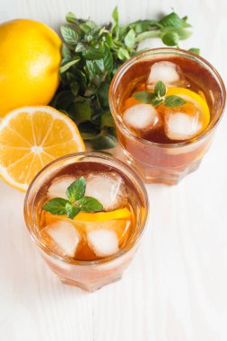 Narenciye limonata yenileniyor, içki yaz. Buzlu çay taze limon ve nane ahşap arka plan üzerinde. Ferahlık içecek konsepti.