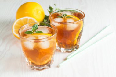Narenciye limonata yenileniyor, içki yaz. Buzlu çay taze limon ve nane ahşap arka plan üzerinde. Ferahlık içecek konsepti.