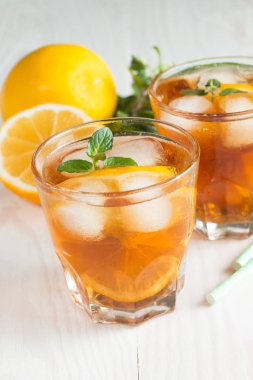 Narenciye limonata yenileniyor, içki yaz. Buzlu çay taze limon ve nane ahşap arka plan üzerinde. Ferahlık içecek konsepti.