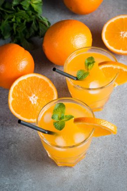 Ahşap ve taş zemin üzerine portakal meyve ile portakal suyu bir bardak close-up. Vitamin ve mineraller. Sağlıklı içki ve içecek konsepti.