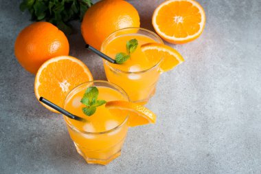 Ahşap ve taş zemin üzerine portakal meyve ile portakal suyu bir bardak close-up. Vitamin ve mineraller. Sağlıklı içki ve içecek konsepti.