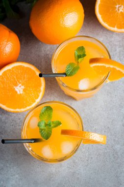 Ahşap ve taş zemin üzerine portakal meyve ile portakal suyu bir bardak close-up. Vitamin ve mineraller. Sağlıklı içki ve içecek konsepti.