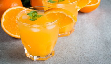 Ahşap ve taş zemin üzerine portakal meyve ile portakal suyu bir bardak close-up. Vitamin ve mineraller. Sağlıklı içki ve içecek konsepti.