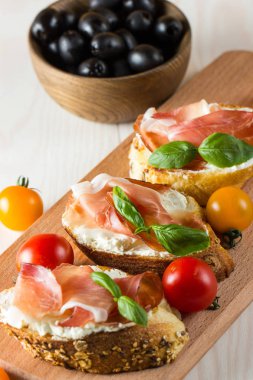 İtalyan domates, jambon, jamon, jambon ve peynir bruschetta. Tapas, antipasti Doğranmış sebzeler, otlar ve petrol ızgara ciabatta ve baget ekmek.
