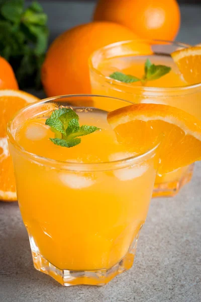 Ahşap ve taş zemin üzerine portakal meyve ile portakal suyu bir bardak close-up. Vitamin ve mineraller. Sağlıklı içki ve içecek konsepti.