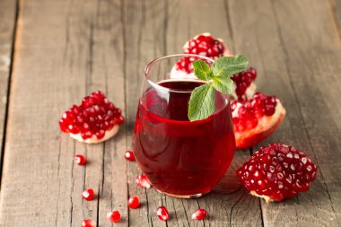 Bir bardak nar suyu ve ahşap masada taze nar meyveleri. Vitamin ve mineraller. Sağlıklı içki konsepti.