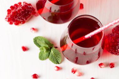 Bir bardak nar suyu ve ahşap masada taze nar meyveleri. Vitamin ve mineraller. Sağlıklı içki konsepti.