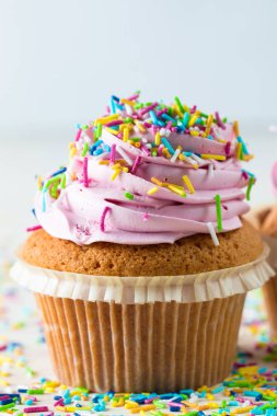 Vanilya, çilek, pembe ve beyaz krem, çikolata ve ahşap arka plan üzerinde ile cupcakes closeup. Seçici odak. Şekerli tatlı lezzetli yemekler kavramı muffin.