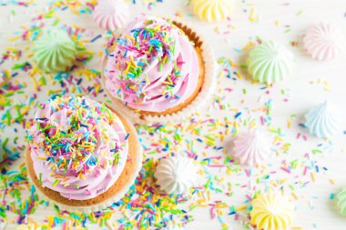 Vanilya, çilek, pembe ve beyaz krem, çikolata ve ahşap arka plan üzerinde ile cupcakes closeup. Seçici odak. Şekerli tatlı lezzetli yemekler kavramı muffin.