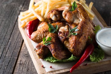 Yakın çekim fotoğraf Barbekü tavuk kanatlı patates ve bira. Barbekü soslar, ketçap, mayonez etli. Hızlı ve abur cubur kavramı. 