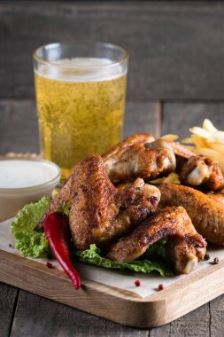 Yakın çekim fotoğraf Barbekü tavuk kanatlı patates ve bira. Barbekü soslar, ketçap, mayonez etli. Hızlı ve abur cubur kavramı. 