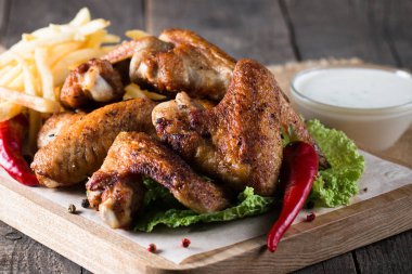 Yakın çekim fotoğraf Barbekü tavuk kanatlı patates ve bira. Barbekü soslar, ketçap, mayonez etli. Hızlı ve abur cubur kavramı. 