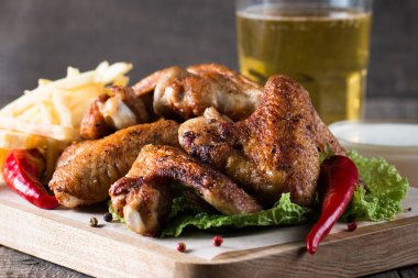 Yakın çekim fotoğraf Barbekü tavuk kanatlı patates ve bira. Barbekü soslar, ketçap, mayonez etli. Hızlı ve abur cubur kavramı. 