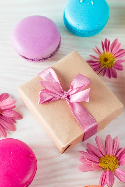 Photo of cake macarons, gift box, tea, coffee, cappuccino and flowers. Sweet romantic food macaroon concept. Morning breakfast and presents. Valentine\'s day concept.