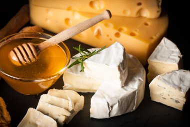 Kayrak kurulu çeşitli peynir ve kırmızı gül şarap ile. Brie. Camembert. Gouda, Masdaam, rokfor, kaşar ve üzüm fındık, tatlım, kraker, ahşap üzerine peynir mavi. İtalyan, Fransız peynir.