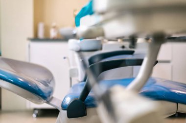 Dişçi sandalyesi, yan görüş, mavi beyaz arka plan ve enstrüman masası