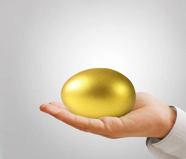 Рука тримає золоті яйця — стокове фото