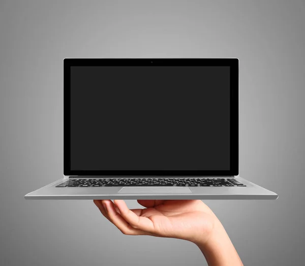 Hand holding a laptop — Stockfoto
