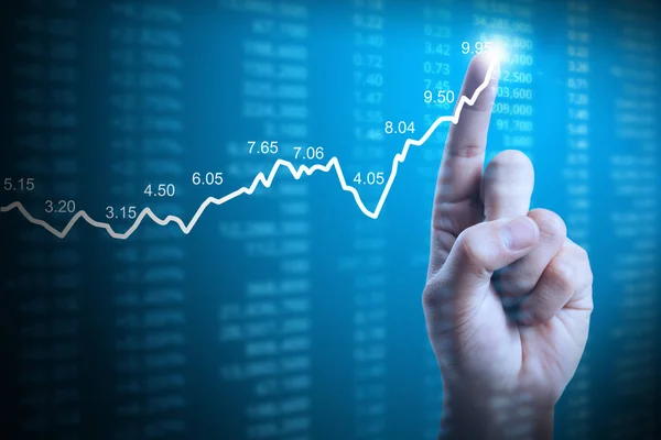 Podnikatel s finanční graf symboly pocházející z ruky — Stock fotografie