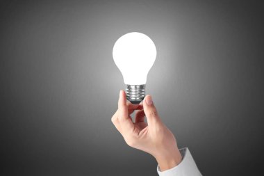 bir ampul ile enerji tutan el 