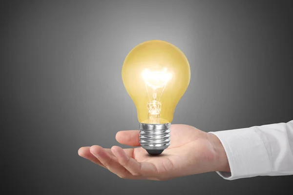 Hand holding light bulb with energy — Stock Photo, Image