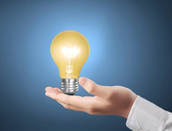 Hand som håller glödlampan med energi — Stockfoto