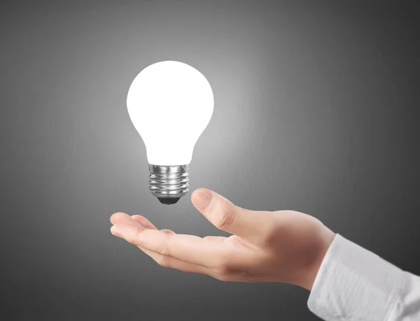Hand holding light bulb with energy Stock Photo