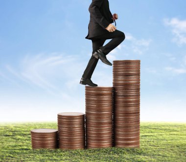 İşadamı, başarı ve yatırımı artıran madeni paraların üzerinde yürüyor