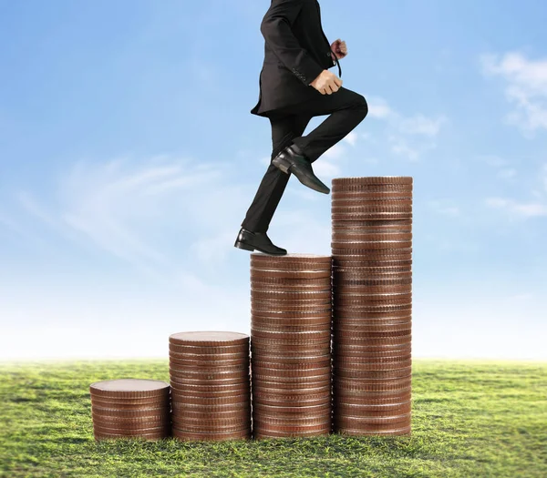 İşadamı, başarı ve yatırımı artıran madeni paraların üzerinde yürüyor