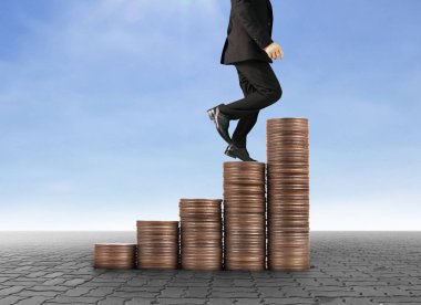 İşadamı, başarı ve yatırımı artıran madeni paraların üzerinde yürüyor