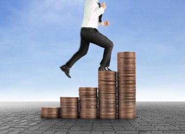 İşadamı, başarı ve yatırımı artıran madeni paraların üzerinde yürüyor