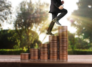 İşadamı, başarı ve yatırımı artıran madeni paraların üzerinde yürüyor