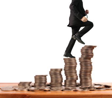 İşadamı, başarı ve yatırımı artıran madeni paraların üzerinde yürüyor