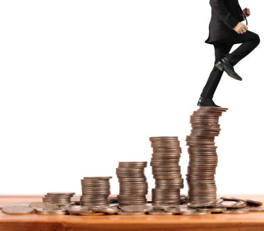 İşadamı, başarı ve yatırımı artıran madeni paraların üzerinde yürüyor