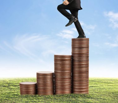 İşadamı, başarı ve yatırımı artıran madeni paraların üzerinde yürüyor