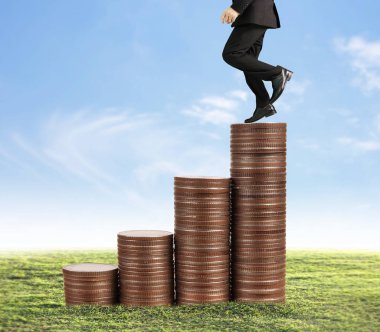 İşadamı, başarı ve yatırımı artıran madeni paraların üzerinde yürüyor