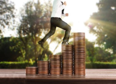 İşadamı yürümek sikkelerin yığın üzerinde başarı yetişen 