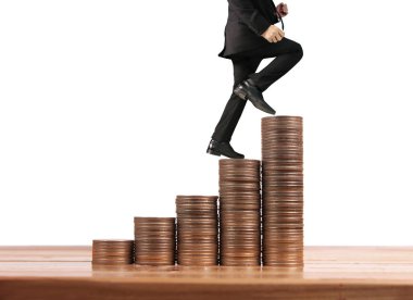 İşadamı, başarı ve yatırımı artıran madeni paraların üzerinde yürüyor