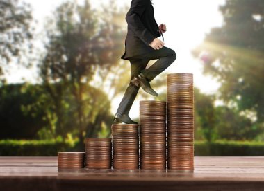 İşadamı, başarı ve yatırımı artıran madeni paraların üzerinde yürüyor