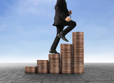 İşadamı, başarı ve yatırımı artıran madeni paraların üzerinde yürüyor