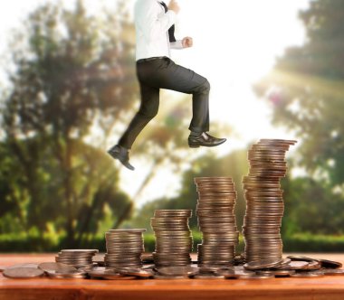 İşadamı, başarı ve yatırımı artıran madeni paraların üzerinde yürüyor