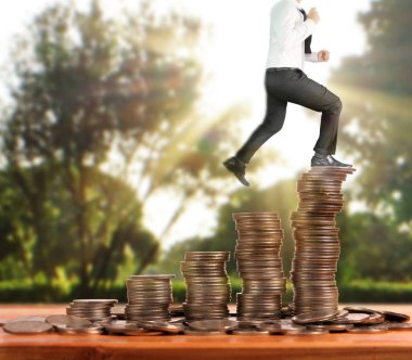 İşadamı, başarı ve yatırımı artıran madeni paraların üzerinde yürüyor