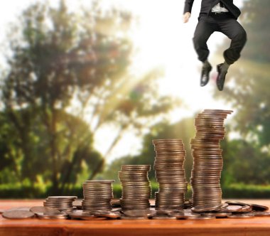 İşadamı, başarı ve yatırımı artıran madeni paraların üzerinde yürüyor