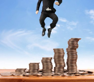 İşadamı yürümek sikkelerin yığın üzerinde başarı yetişen 