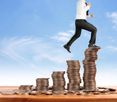 İşadamı, başarı ve yatırımı artıran madeni paraların üzerinde yürüyor
