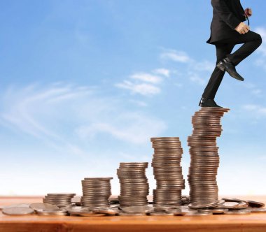 İşadamı, başarı ve yatırımı artıran madeni paraların üzerinde yürüyor