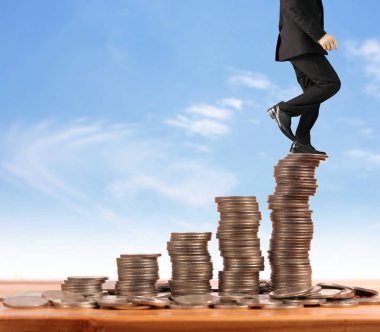 İşadamı yürümek sikkelerin yığın üzerinde başarı yetişen 
