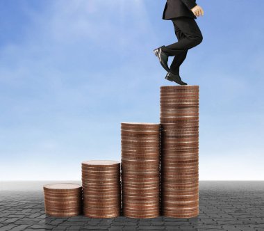 İşadamı, başarı ve yatırımı artıran madeni paraların üzerinde yürüyor