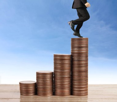 İşadamı yürümek sikkelerin yığın üzerinde başarı yetişen 